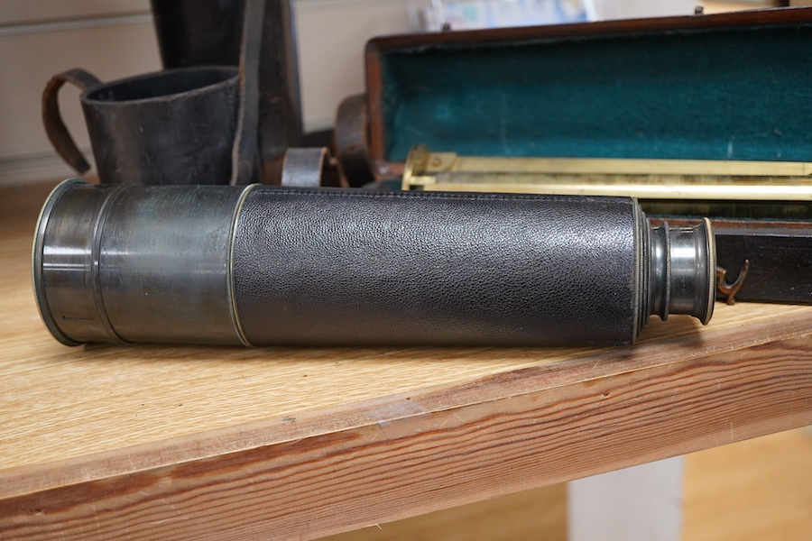 An early 20th century four draw brass telescope with leather grip, together with a brass table top tripod stand, both unmarked, both parts in separate fitted cases, the telescope fully extended 106cm, contracted 28cm